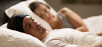 a couple lying in bed together asleep using SleepPhones as a sleeping pill alternative