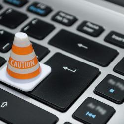 a traffic cone advising caution on a laptop keyboard